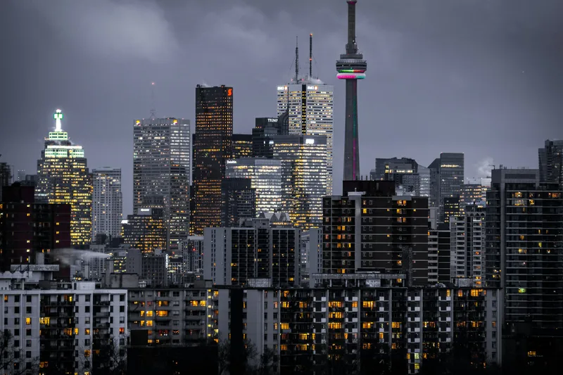 Global city skyline at dusk with financial district towers reflected in water — best places to invest in property 2026